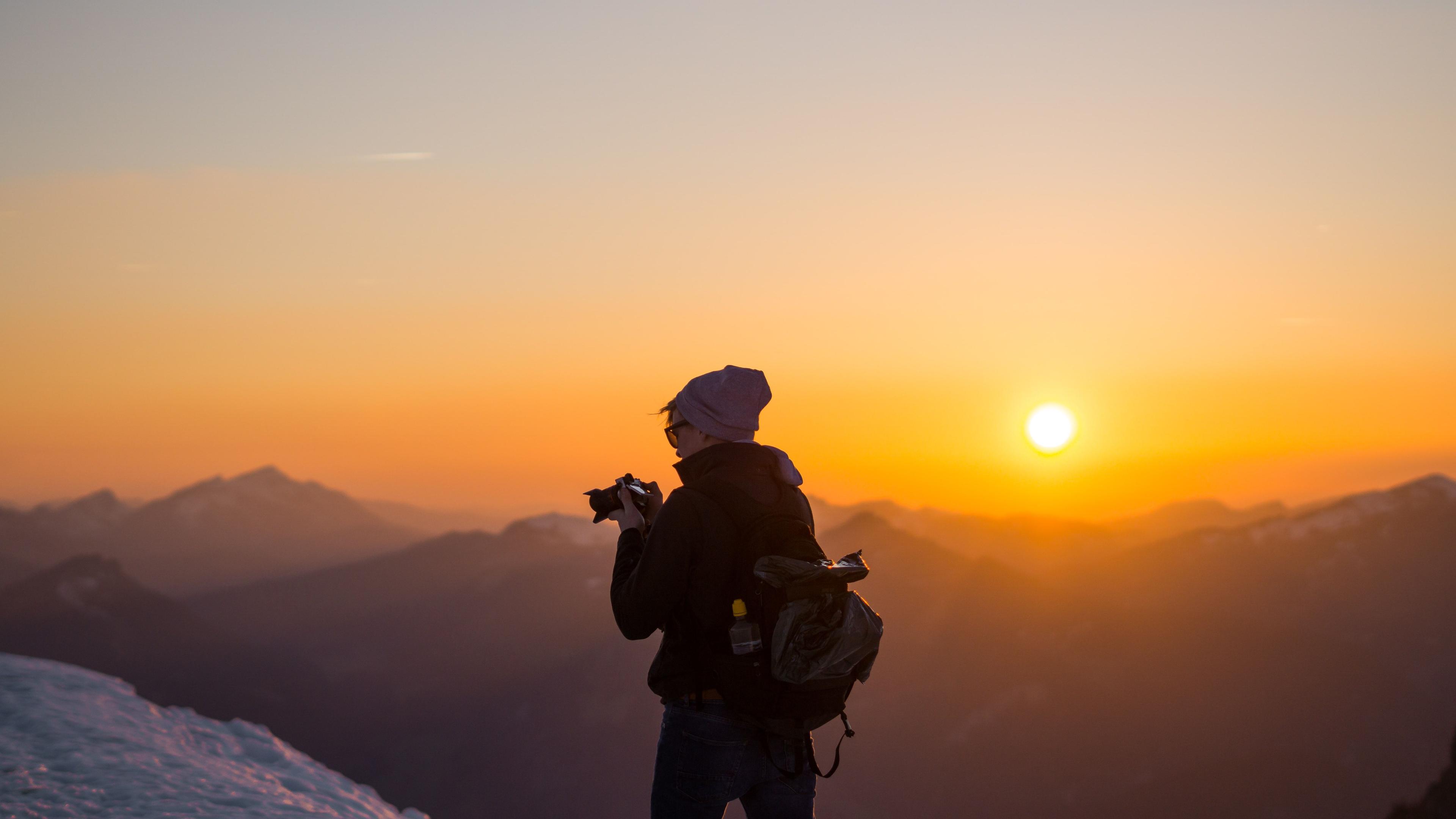 Photographer in nature taking a picture of a sunrise